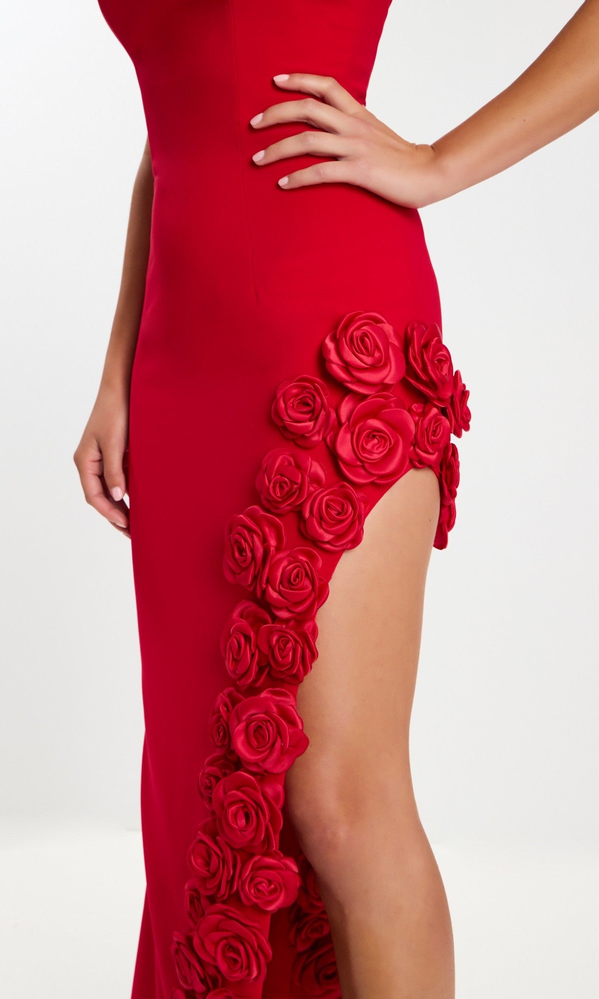 A person strikes a pose in the Jovani 47798 long prom dress, featuring a strapless crepe design with 3D floral appliques on a thigh-high slit and a fitted column silhouette.